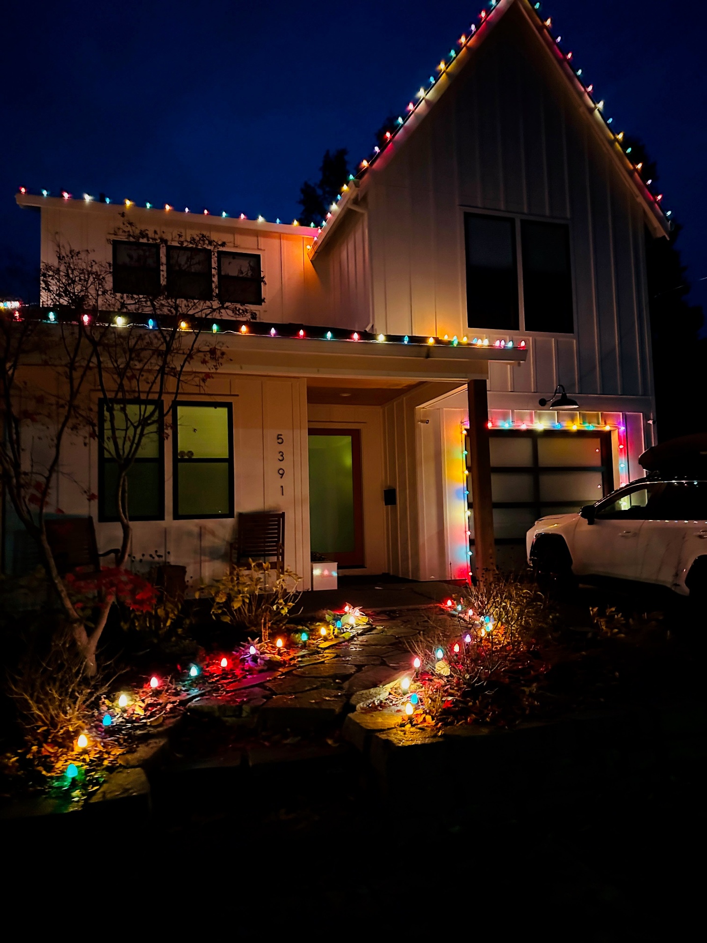 Multicolor C9 rooflines with pathway and landscape lighting on a modern farmhouse